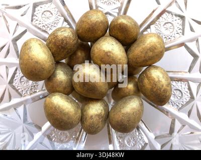 Gold coloured chocolate Easter eggs isolated on background Stock Photo