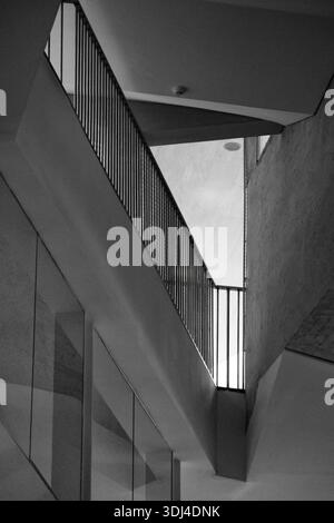 Low Angle Monochrome Abstract of Modern Staircase Architecture with Sharp Geometric Angles and Vertical Railings. Stock Photo