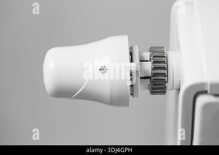 Radiator thermostat valve closeup on white heater. Home heating control detail. Temperature regulation and energy saving concept. Central heating. Stock Photo