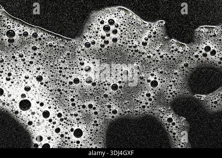 Soap foam texture background. Abstract bubbles and detergent suds in water. Cleaning and hygiene concept. Macro surface detail with high contrast. Stock Photo