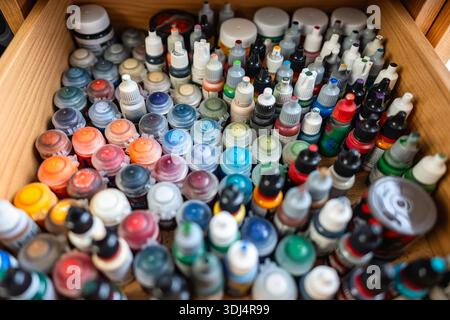 Many small pots of multi-colored paint for painting miniatures of board games for adults. Stock Photo