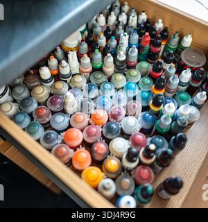 Many small pots of multi-colored paint for painting miniatures of board games for adults. Stock Photo