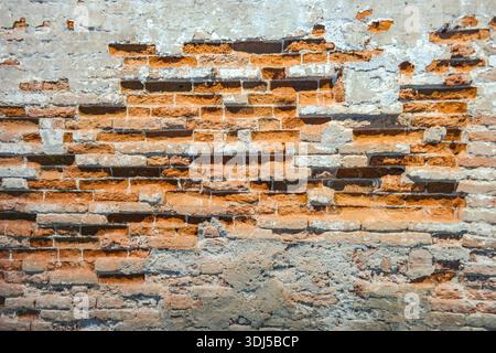 Exposed brick wall with crumbling plaster, historic masonry texture, Venice, Italy Stock Photo
