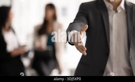 Closeup businessman extending his hand forward in welcoming handshake gesture Stock Photo