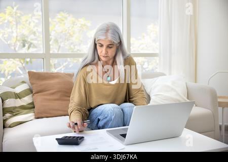 Mature woman focused on financial or work-related task Stock Photo