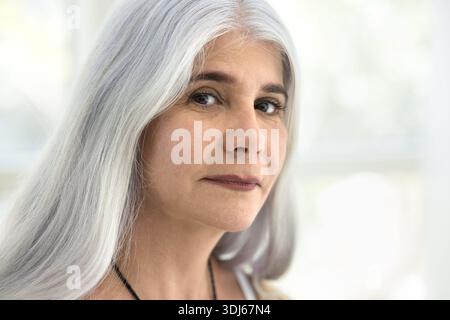 Close-up portrait of middle-aged woman with long, silver hair Stock Photo