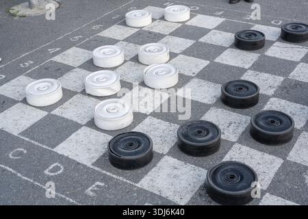 Ulyanovsk, Russia - July 25 2021: Checkers game. Gigantic black and white checkers on the asphalt. Stock Photo