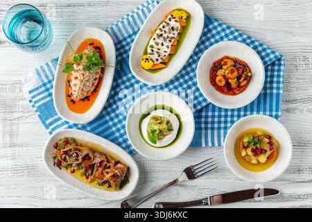 Assorted fish mezze dishes served on table in restaurant Stock Photo