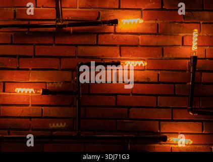 Bulbs illuminating brick wall in a restaurant. Stock Photo