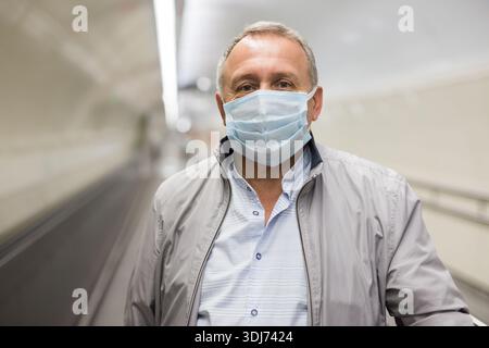 Middle aged man on moving walkway Stock Photo