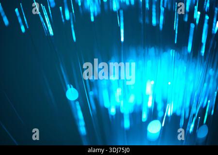 Blue light rays and optical filaments on an abstract background Stock Photo