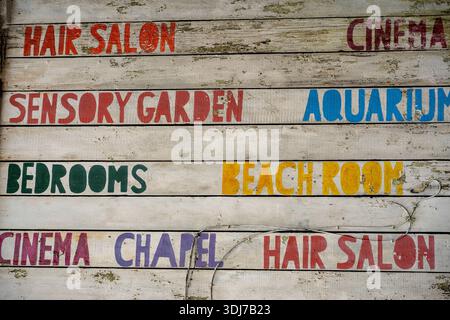 hand painted wooden sign advertising various products and services on the outside of an historic building now repurposed in Portsmouth city centre. Stock Photo