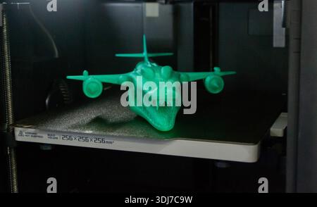 Art model printed on 3D printer from molten plastic. Object created on 3D printer inside printer. Form printed on 3D printer from green plastic on the working surface. Concept 3D printing technology Stock Photo