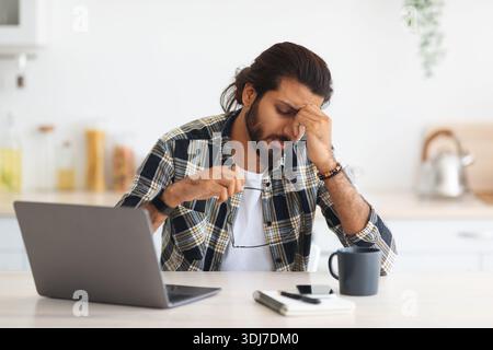 Tired middle-eastern man freelancer having difficulties at job Stock Photo