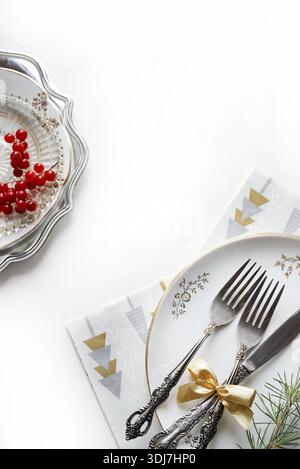 Elegant Christmas table setting with cutlery and plates on a white background. Christmas season and holidays. Christmas concept. Copy space. Stock Photo
