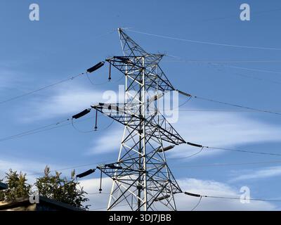 Massive steel electricity pylon against a blue sky Stock Photo