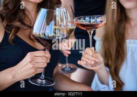 Three female friends drinking wine in restaurant, close up Stock Photo