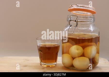 Jar of pickled eggs and glass of vinegar in kitchen Stock Photo