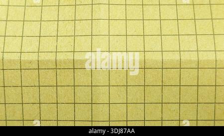 Yellow grid paper background texture on a fibrous recycled paper surface for a vintage look Stock Photo