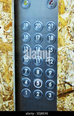 worn metal elevator button panel construction backdrop, closeup vertical view of circular numbered buttons  to , Stock Photo