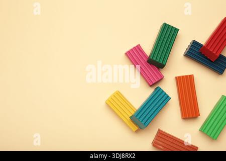 Multi-colored plasticine bricks on beige background. Childrens plasticine close-up. Stock Photo
