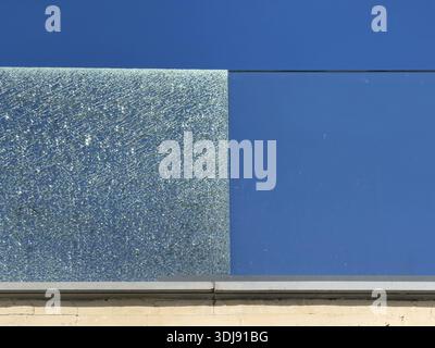 Contrast view of a tempered glass railing on a terrace where one panel is shattered and the other is intact. Damage, safety, and architectural concept Stock Photo