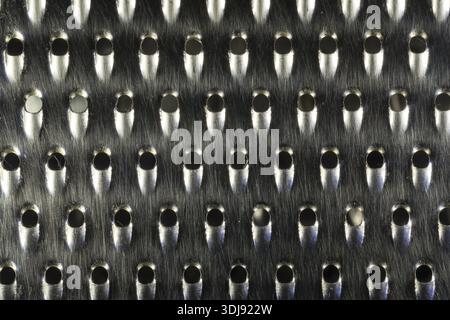 Close-up macro shot of a worn and used metal kitchen cheese or food grater Stock Photo