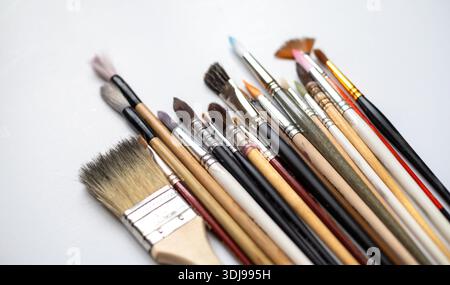 Variety of brushes set on a white background, including a flat brush, calligraphy brushes, and watercolor brushes. Art supplies for painting, in vario Stock Photo