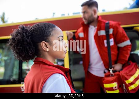 Paramedic nurse and emergency doctor at ambulance with kit. a paramedic, standing at the rear of an ambulance, by the open doors. Stock Photo
