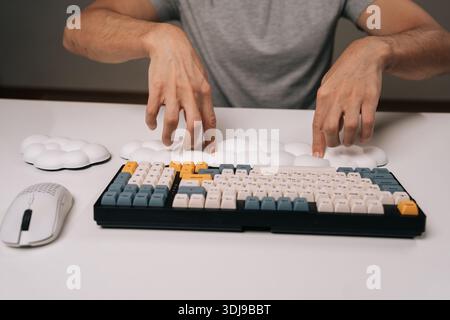 Person placing cloud-shaped wrist rest for ergonomic comfort while using mechanical keyboard and wireless mouse on clean white desk, highlighting Stock Photo