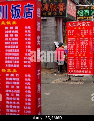 Seen from behind, a woman talks on the phone in an old-fashioned, popular telephone call center. Beijing, China, 2010. Stock Photo