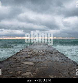 Waves crashing against a stone pier Stock Photo