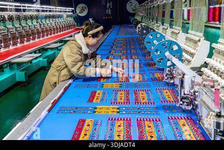 CONGJIANG, CHINA - JANUARY 25, 2026 - A worker is using a CNC machine to produce embroidery products in a production workshop of an embroidery enterprise in Congjiang County, Guizhou Province, China on January 25, 2026. Stock Photo
