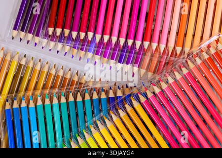 Packs of colored pencils sit on flat surface displaying their bright colors for artists students to use. Stock Photo