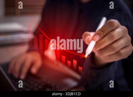 Economic downturn concept with businessman with laptop, analyzing declining bar chart while draw red falling arrow. Financial crisis, inflation foreca Stock Photo