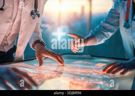 Two medical professionals interacting with touch screen in a futuristic setting, analyzing data and collaborating on innovative healthcare solutions Stock Photo