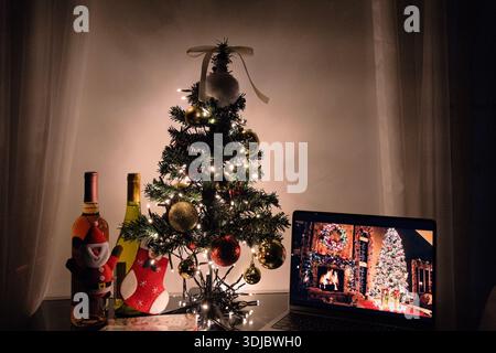 Cozy indoor Christmas scene with a decorated tree, warm string lights, and festive holiday decorations on a tabletop. Stock Photo