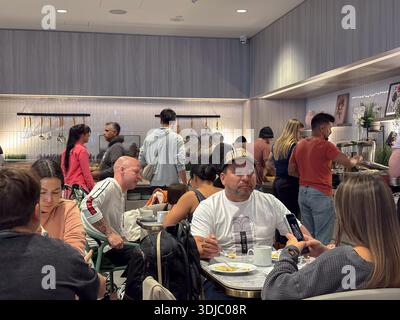 Passengers eating and conversing in a modern airport lounge at Toronto Pearson International Airport. Travel, waiting, dining. Stock Photo