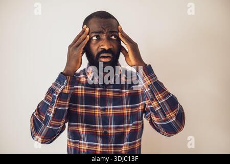 Portrait of black man who is anxious and having headache. Stock Photo