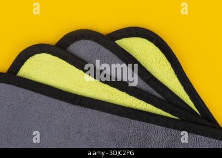 Cleaning cloth stack isolated. Wipe rag, cleaning microfiber towel, wiping cotton napkin, microfibre fabric, kitchen cloths on yellow background Stock Photo