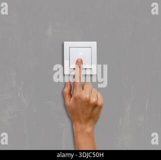 Close-up of hand switching light on at home Stock Photo