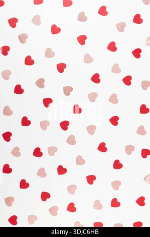 Top view of red and pink glitter hearts on white background. Valentine's day, pink glitter hearts, red hearts, love wallpaper. Flat lay, copy space. Stock Photo
