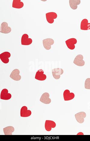 Top view of red and pink glitter hearts on white background. Valentine's day, pink glitter hearts, red hearts, love wallpaper. Flat lay, copy space. Stock Photo