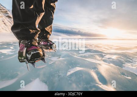 close up of crampons biting into surface of glacier ice at sunset Stock Photo