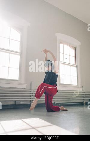 Female dancer performing contemporary movement in studio Stock Photo