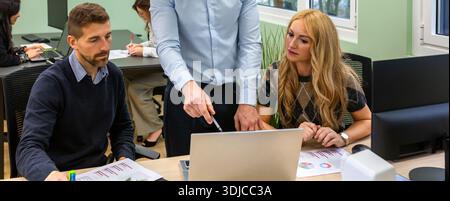 Banner of business people collaborating on a laptop during a meeting in coworking office Stock Photo