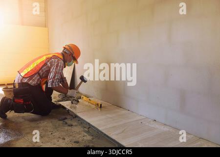 Close-up of a tiler installing ceramic tiles in a new build building Stock Photo