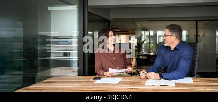 Happy professional executives team discussing papers working in office. Stock Photo