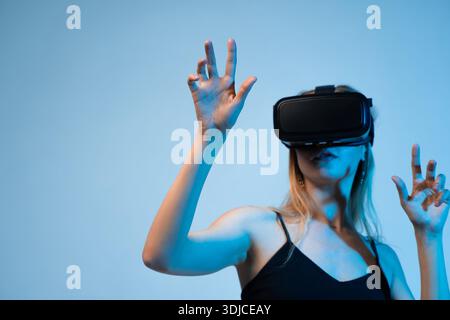 Woman interacting in virtual space using VR headset, immersive digital technology and future innovation Stock Photo