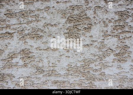Close-up of rough plaster wall with weathered texture and uneven surface, ideal as abstract architectural background Stock Photo